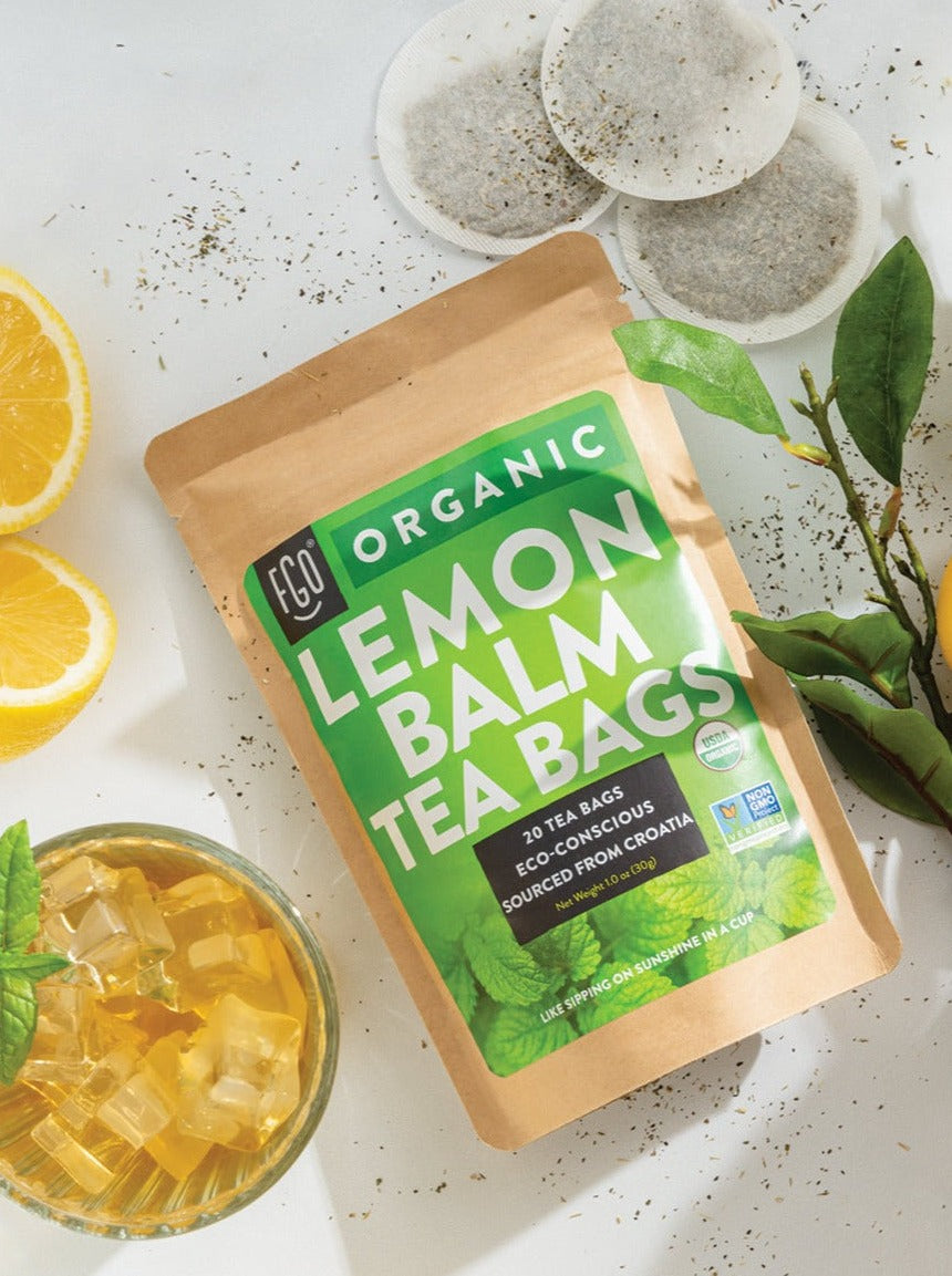 Eco-conscious tea bags and a glass of iced lemon balm tea.