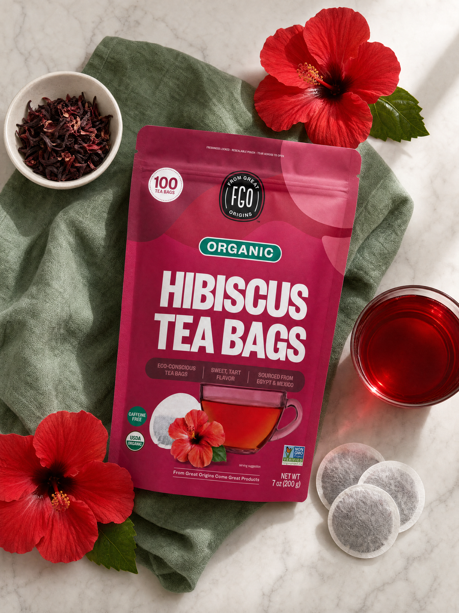Organic Hibiscus Tea Bags on marble with fresh hibiscus flowers, brewed tea and round tea bags