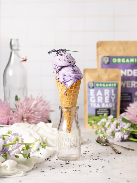 Two scoops of lavender earl grey ice cream in a waffle cone.