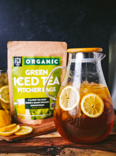 A pitcher of iced green tea with fresh lemon slices.