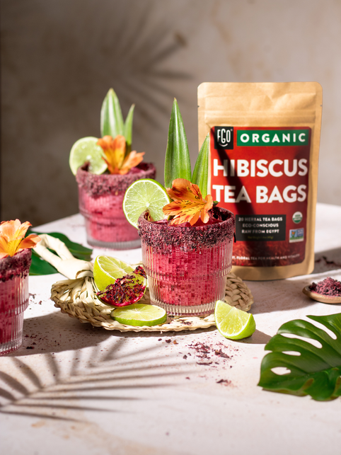 Hibiscus coconut margarita with fresh squeezed lime wedges and a Himalayan salt rim.