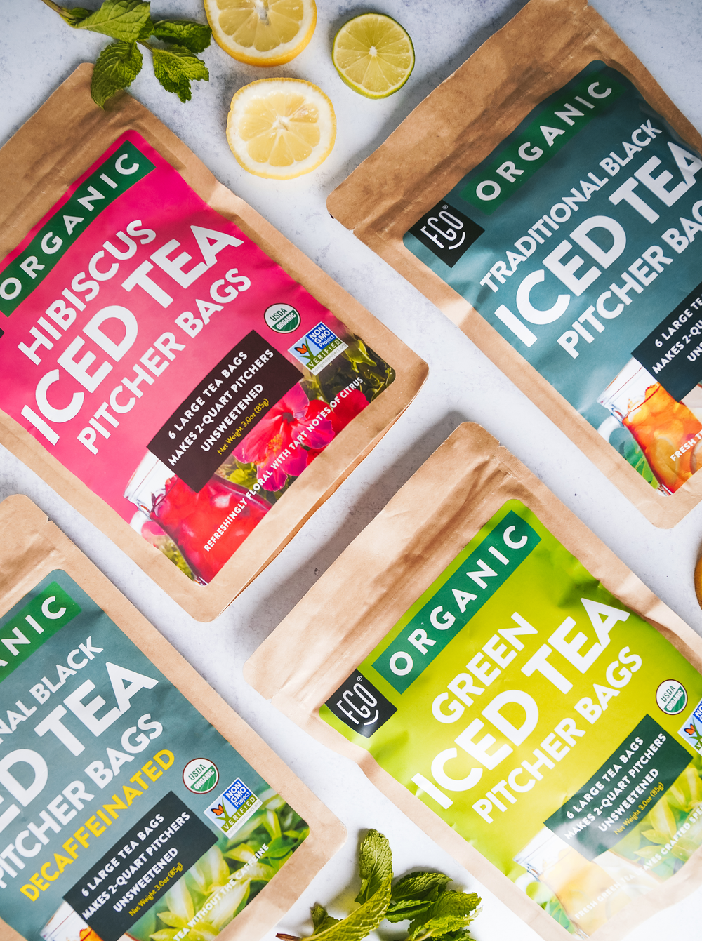 Kraft bags of hibiscus, traditional black, black (decaf), and green ice tea bags.