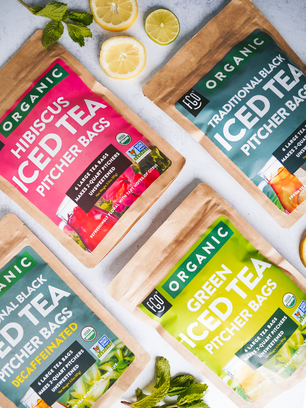 Kraft bags of hibiscus, traditional black, black (decaf), and green ice tea bags.