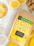 Fresh glass of iced lemon ginger tea bags with fresh squeezed lemons.