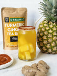 Iced Pineapple Turmeric Ginger Tea with fresh pineapples and a Tajin rim. 