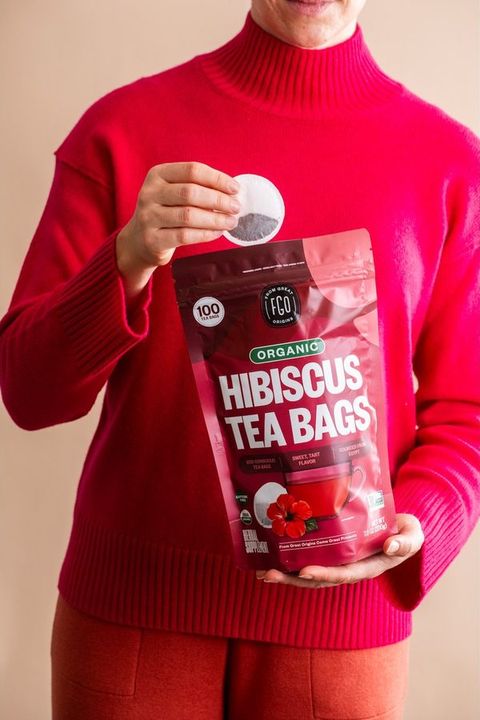 A customer holding a pouch of Hibiscus Tea Bags