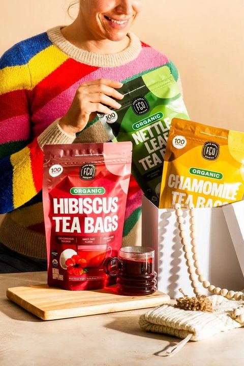 A customer holding three FGO tea pouches