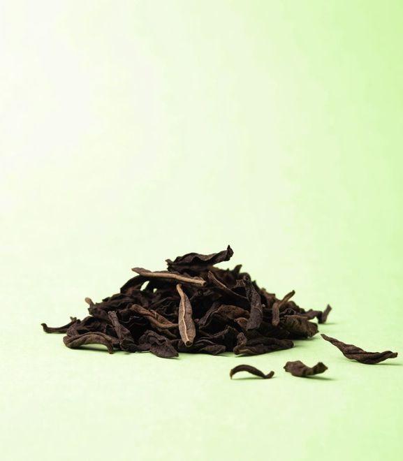 Loose leaf black tea on a pale green ground