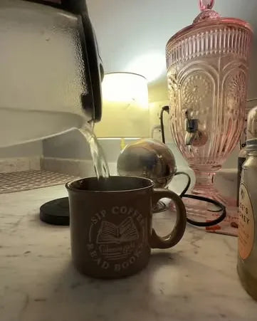 Hot water poured from a kettle into a mug on a kitchen counter