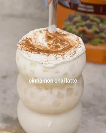 A cinnamon-dusted chai latte in a ribbed glass