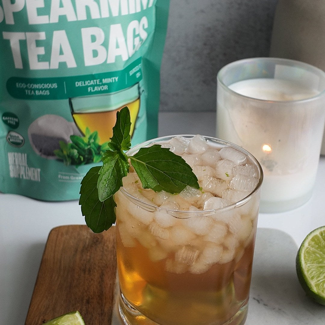 A tall glass of iced spearmint tea garnished with fresh mint